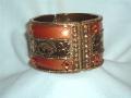 Antique gold and orange colored wide metal bracelet.  The bracelet can be opened completely from one side to help you wear it easily.  Maximum circumference is 9 inches.