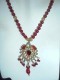 Beautiful kundan necklace from Rajasthan.  The necklace consists of an exquisite kundan pendant attached to a necklace made of gold colored & wine-red beads.<br>
Matching earrings optional.